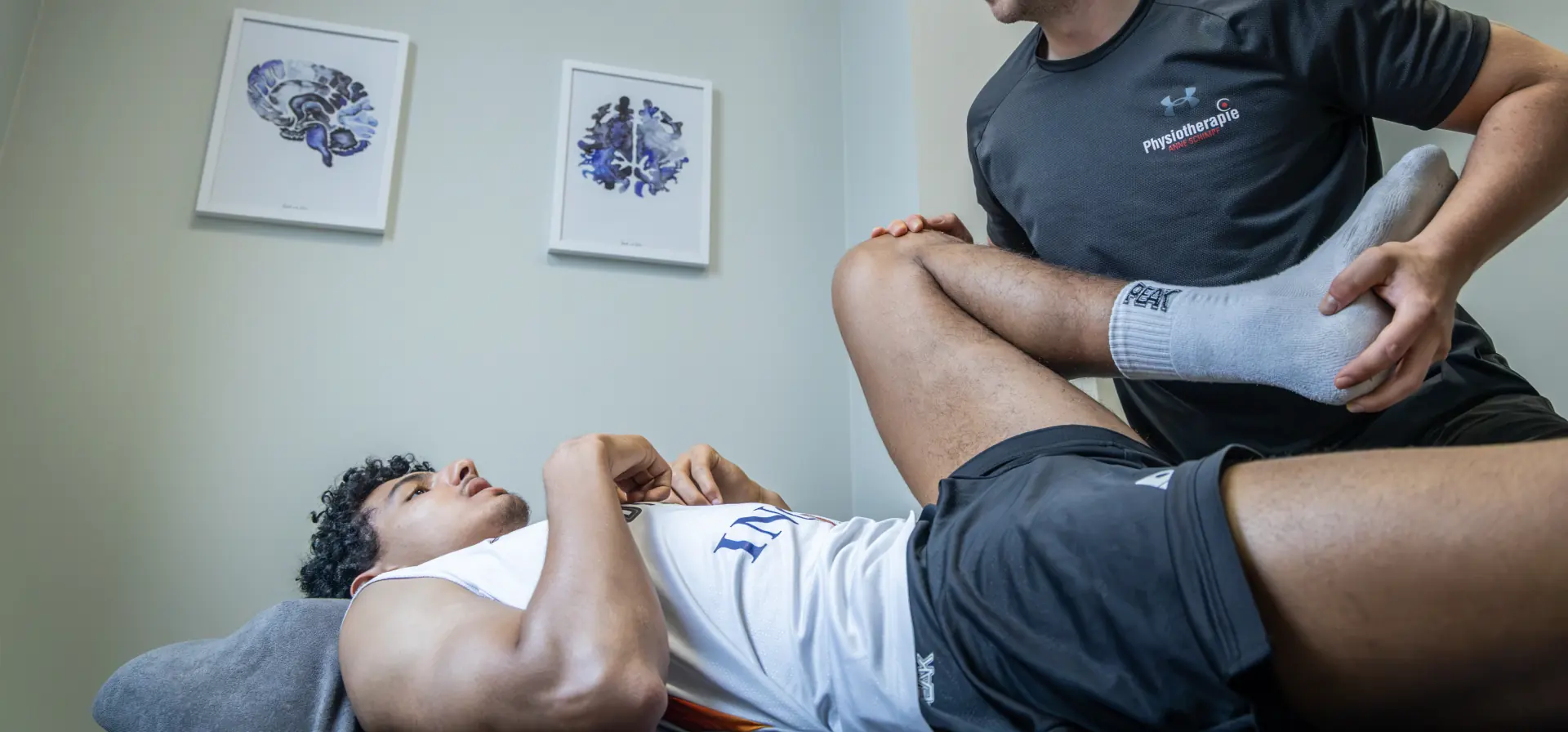Physiotherapeut mobilisiert das Knie eines Patienten auf der Behandlungsliege in der Physiotherapie Anne Schimpf in Halle (Saale)