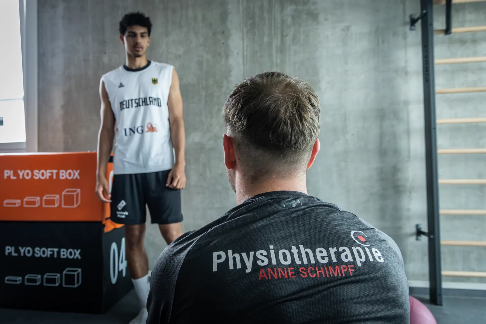 Therapeut der Physiotherapie Anne Schimpf beim Bewegungscheck mit einem Basketballspieler
